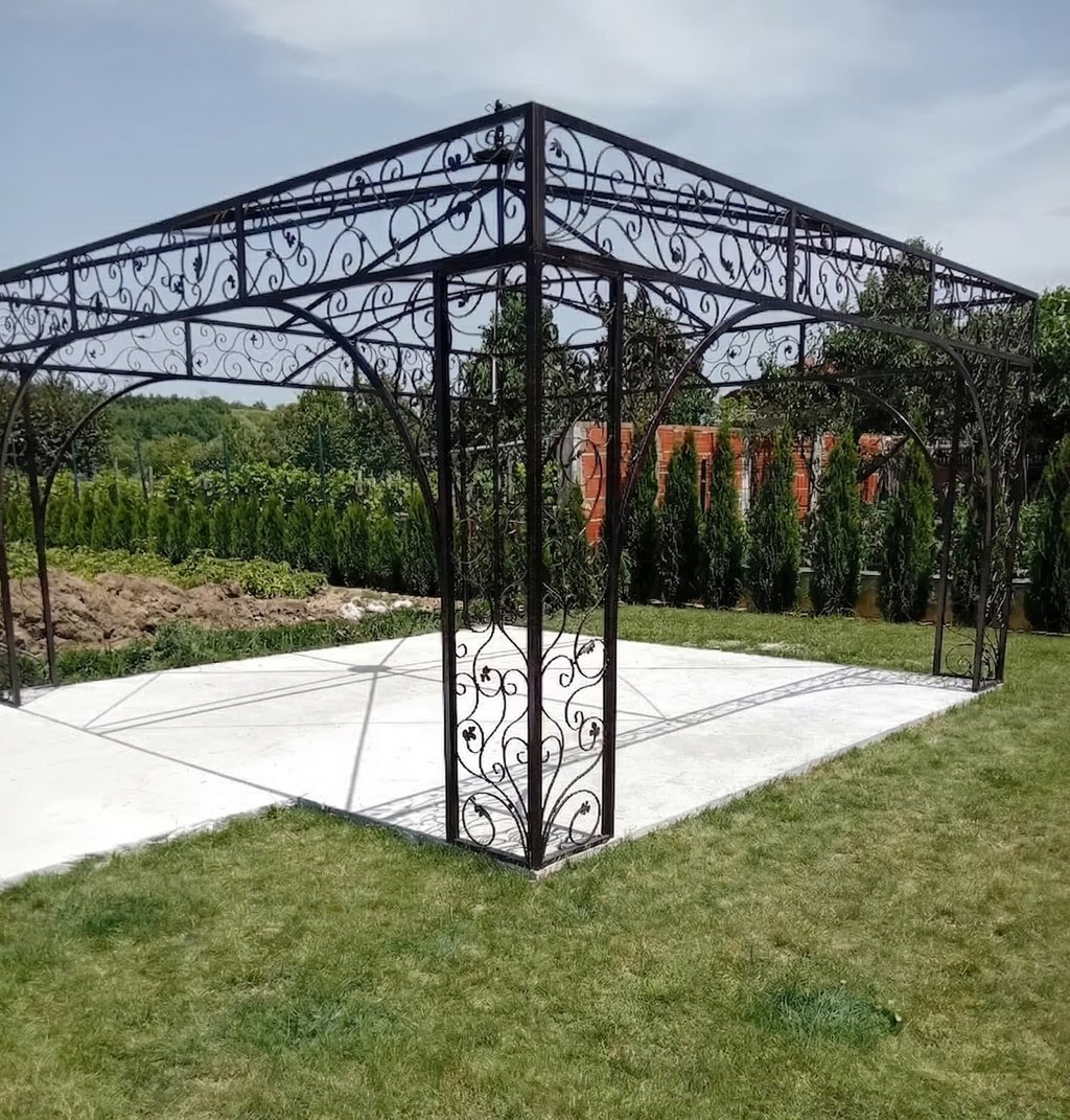 Elegant wrought iron garden gazebo with decorative scrollwork on a white patio base.