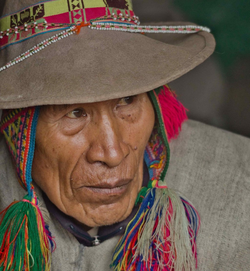 This image shows a close-up portrait of a person from the Andean region wearing traditional clothing.