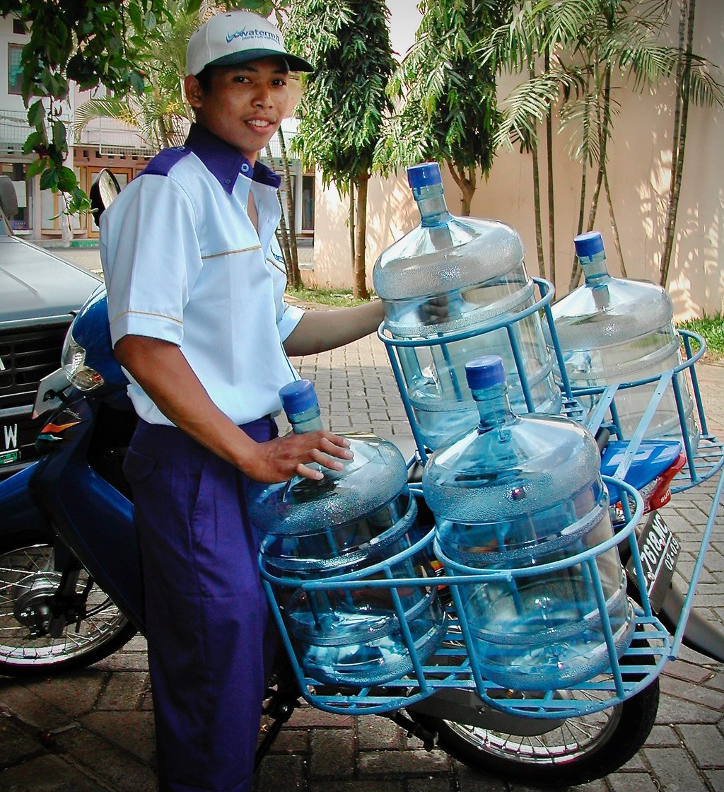 Yamin delivering bottled water by motorbike in Indonesia for Watermill
