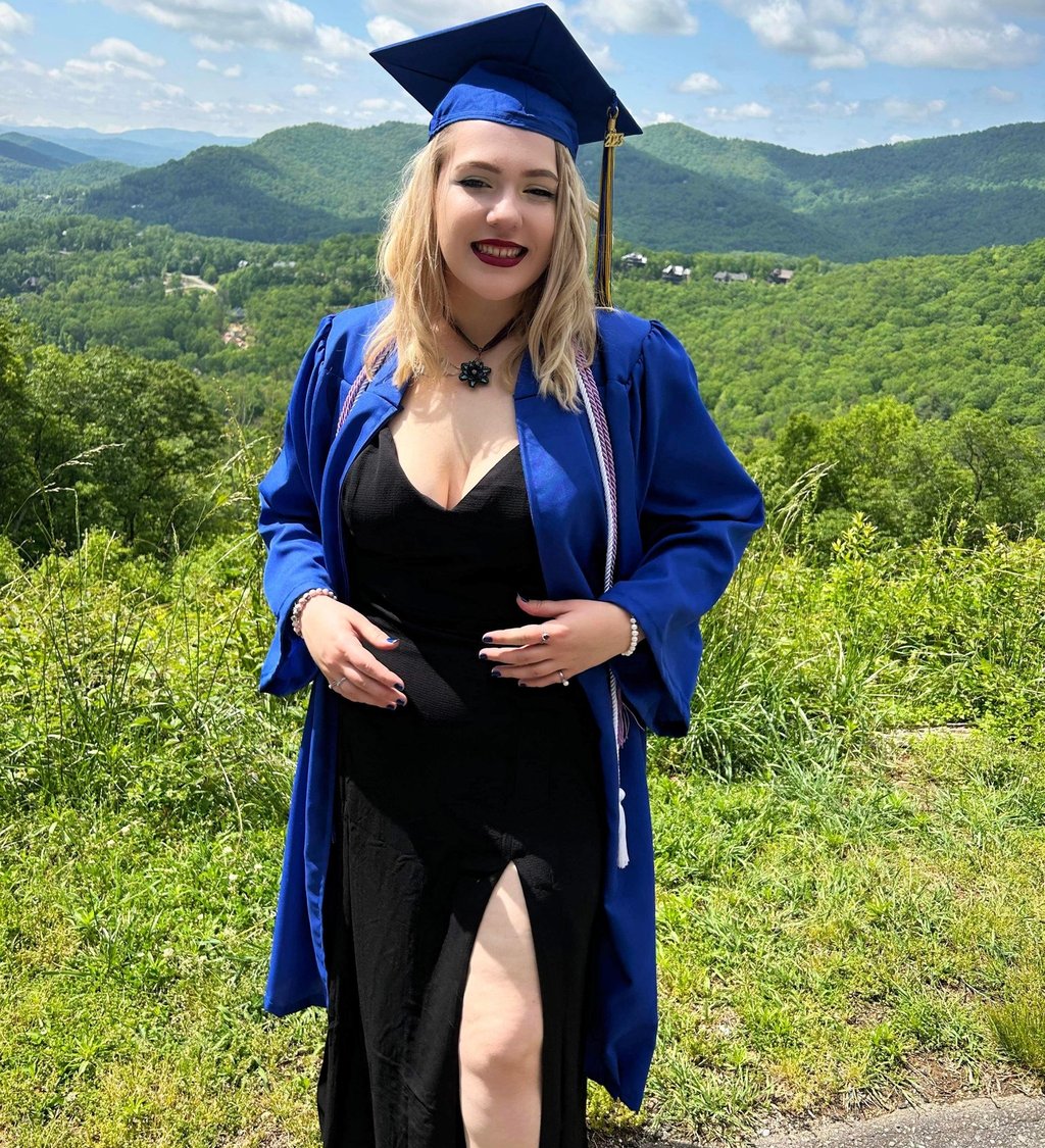a woman in a graduation gown and a graduation cap