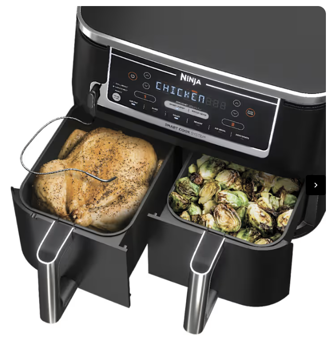 Ninja Foodi dual basket air fryer cooking a whole roast chicken and Brussels sprouts.