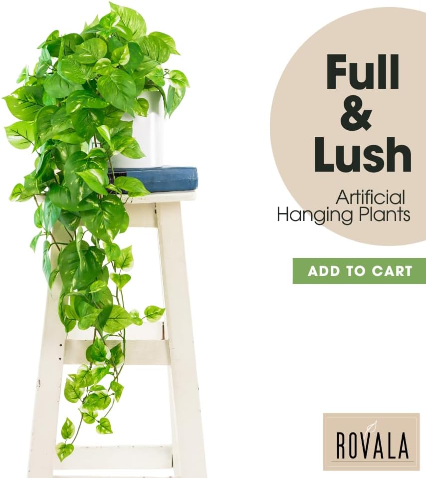 Full and lush artificial hanging pothos plant in a white pot on a wooden stool.