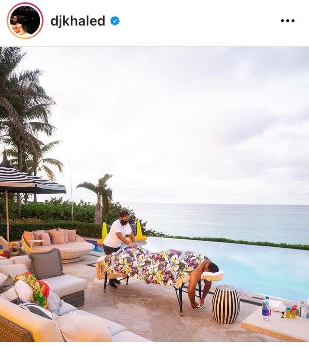 dj khaled having a massage by massages by sophia in front of a pool