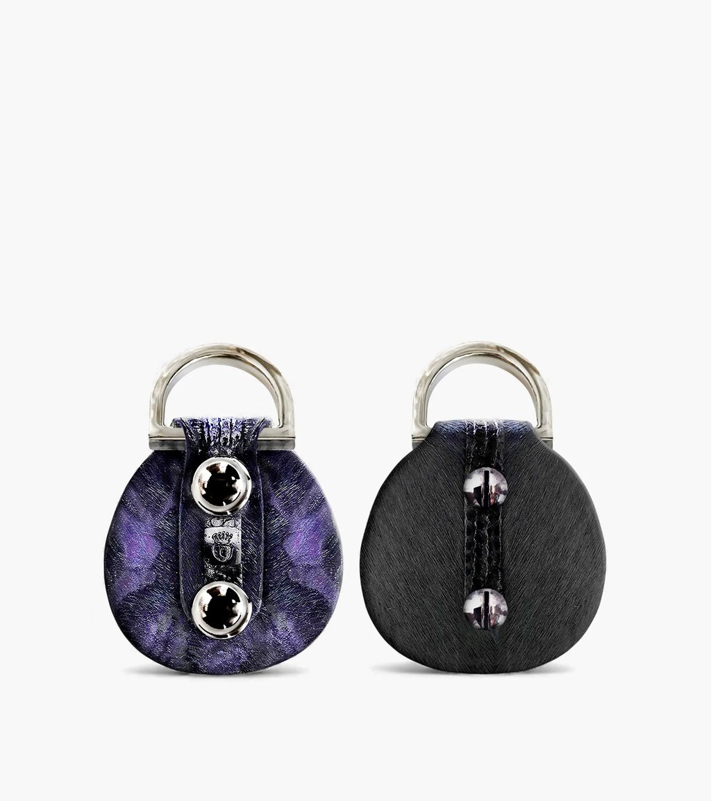 Two circular designer key rings featuring purple marble and black textured finishes with silver hardware.