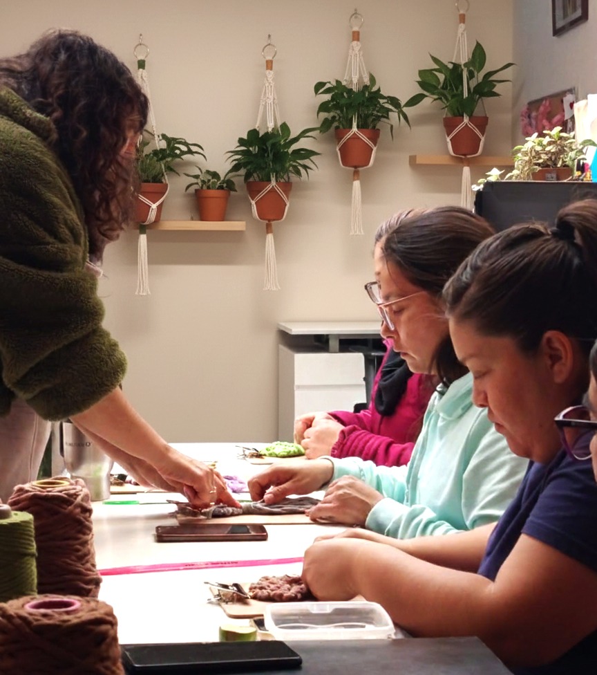 personas aprendiendo macramé y cordones de colores