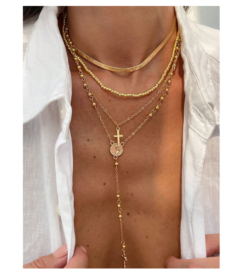 Gold layered necklace set with cross and Virgin Mary pendants.