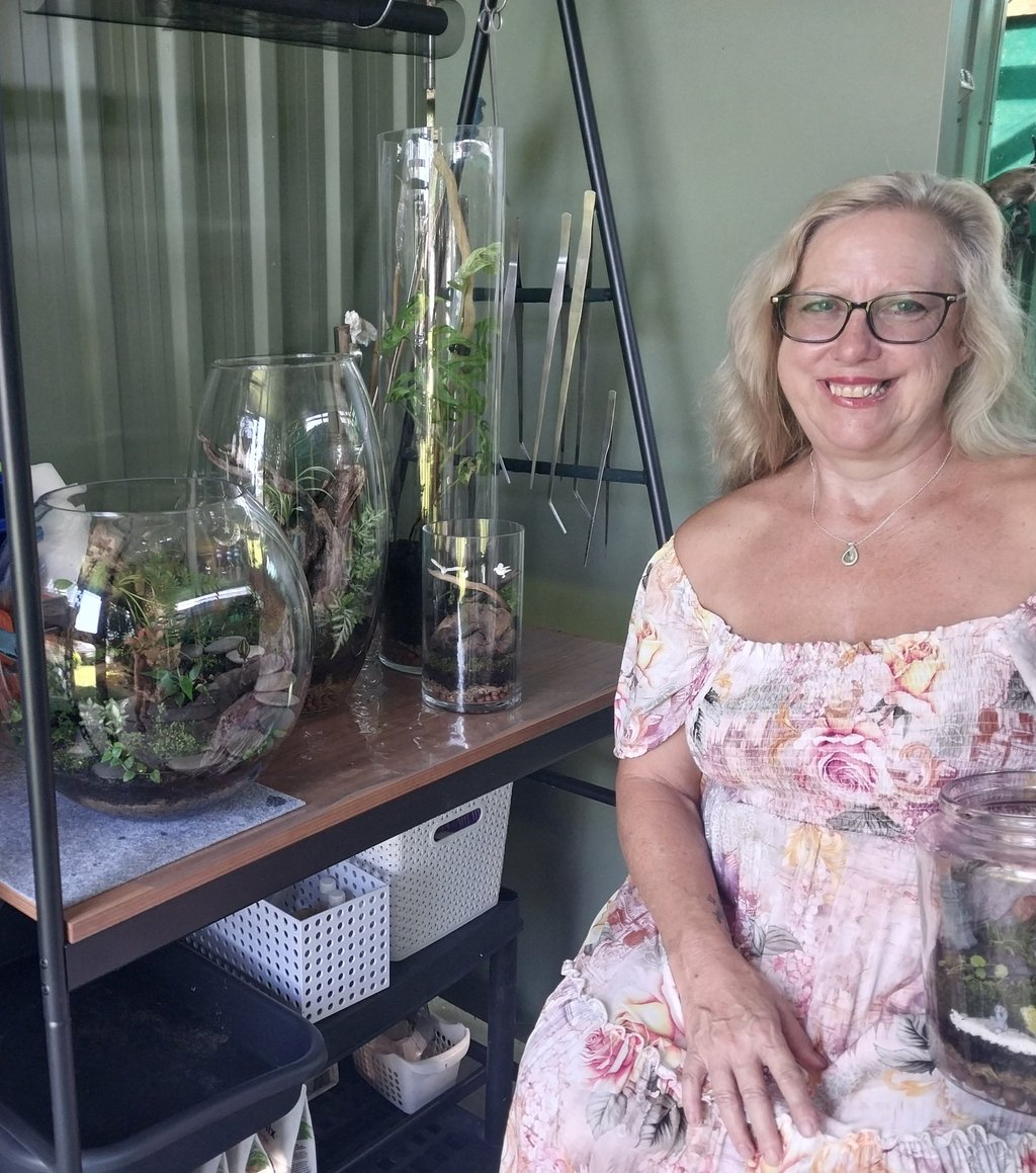 a woman in a floral dress sitting on a shelf