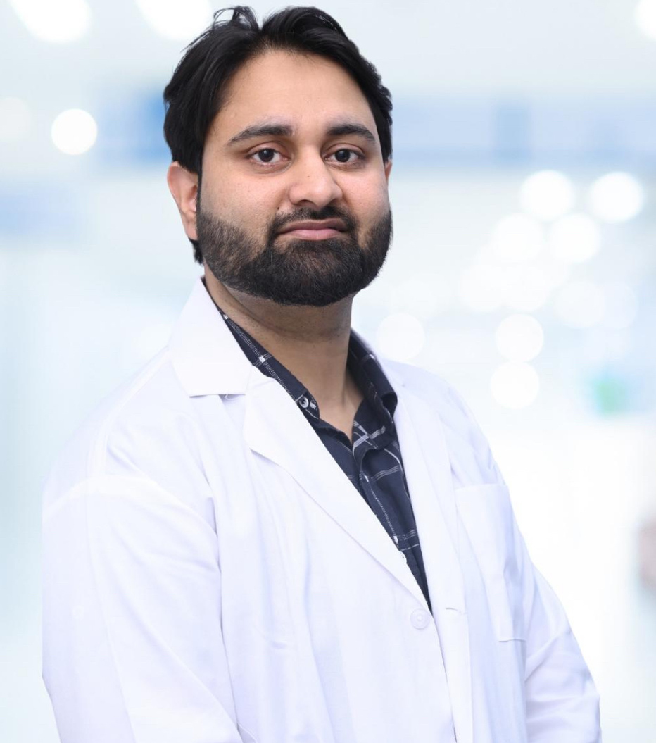 Professional male doctor with a beard wearing a white lab coat in a bright clinic setting.