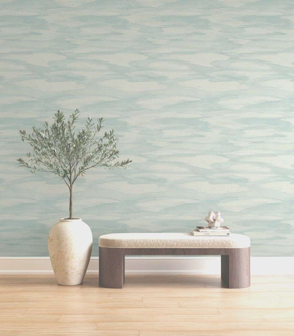 Light blue watercolor wave wallpaper behind a modern wood bench and potted olive tree.