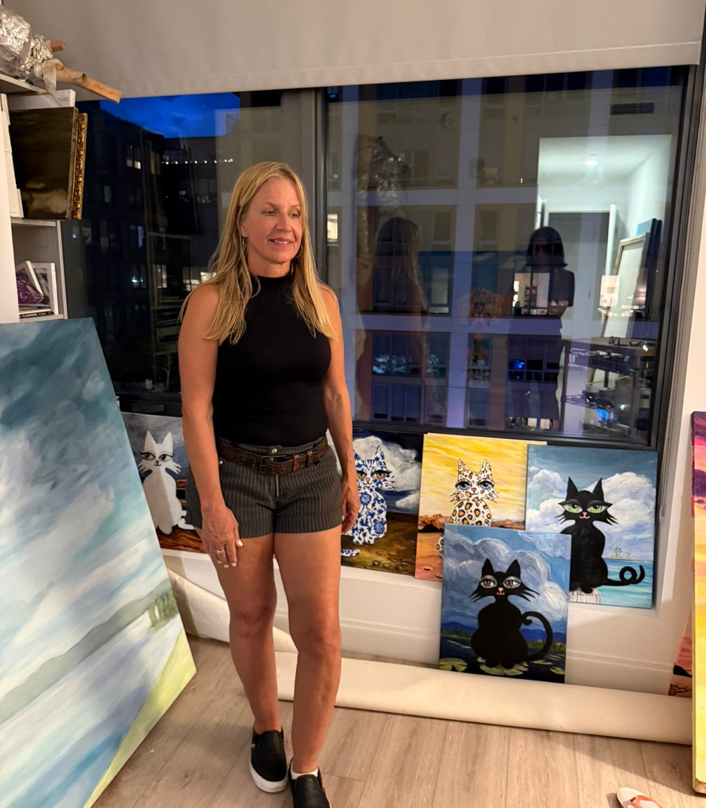 Artist Eve Hennessy in studio with Hawa Cat paintings
