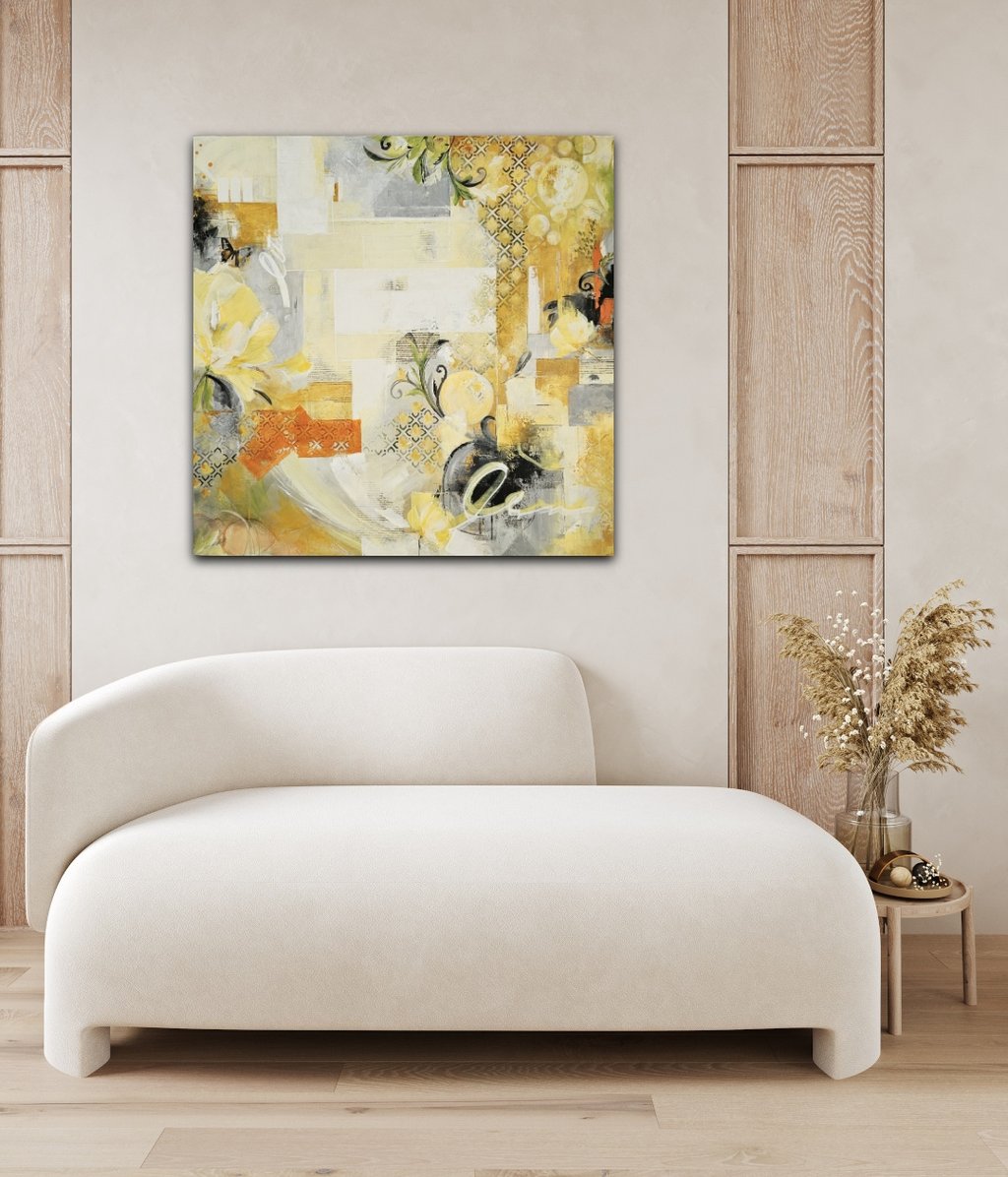 Modern yellow and grey abstract canvas art above a white curved sofa in a minimalist living room.