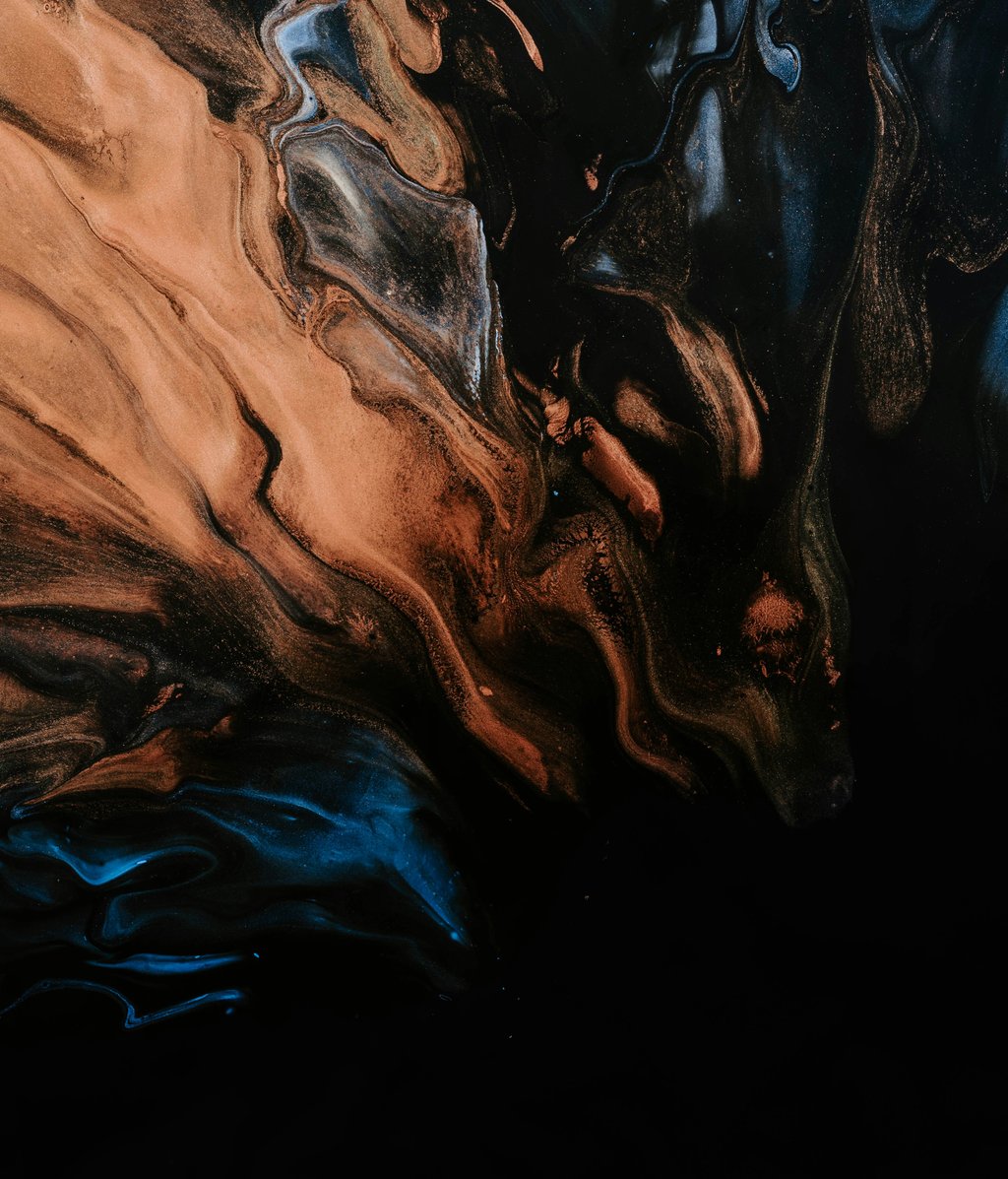 Abstract fluid art featuring swirls of metallic gold, copper, and deep blue acrylic paint on a black background.
