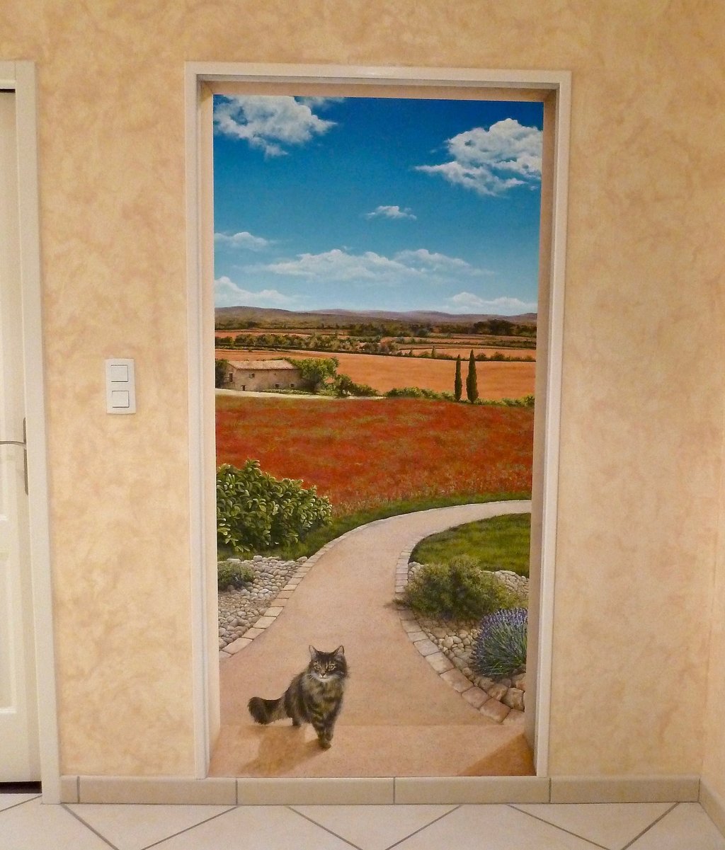 Une porte ouverte sur un paysage méditerranéen, une allée, un chat...Un décor en trompe-l'oeil pour une porte murée.