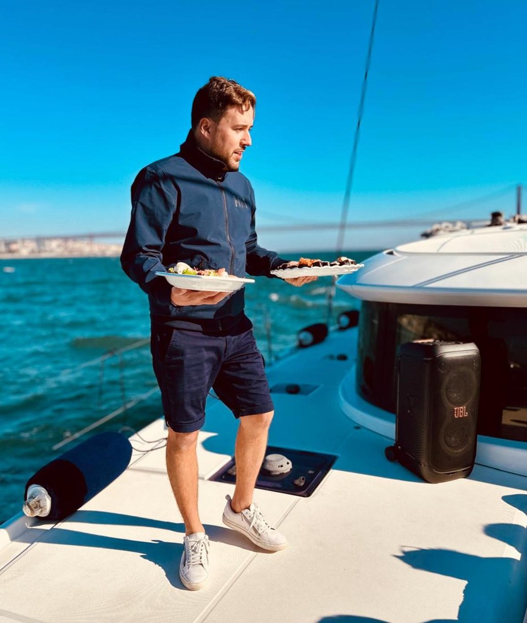 Notre Capitaine proposant des sushis à nos invites lors d'une balade en bateau sur notre catamaran L