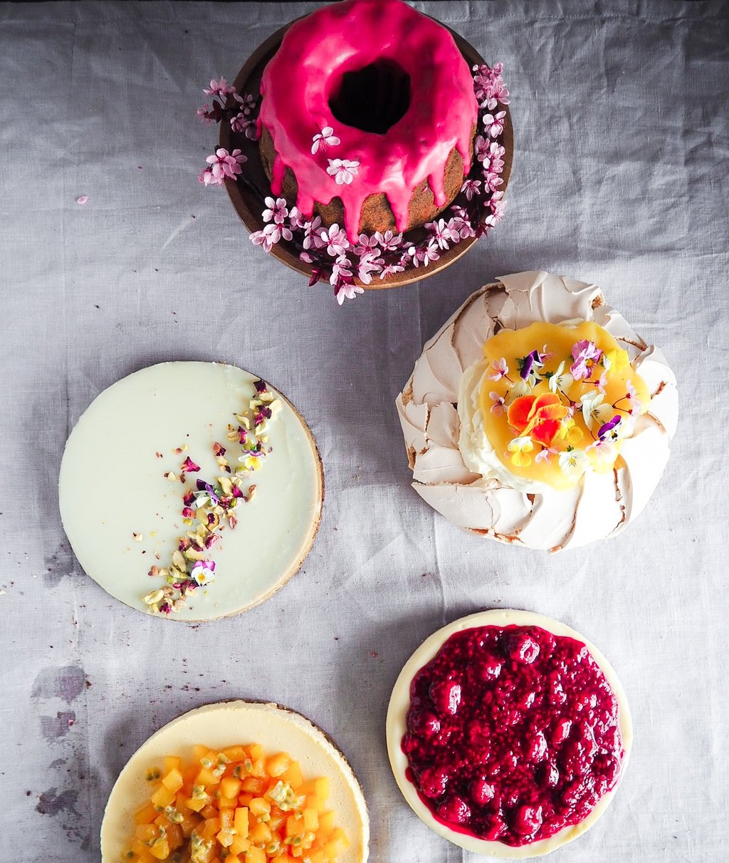 Kolorowe ciasta ustawione na jasnym obrusie widziane z góry