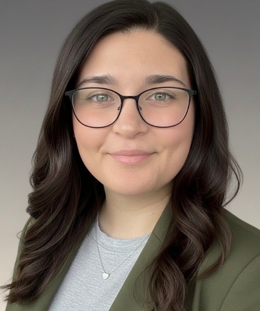 a woman in glasses and a green jacket