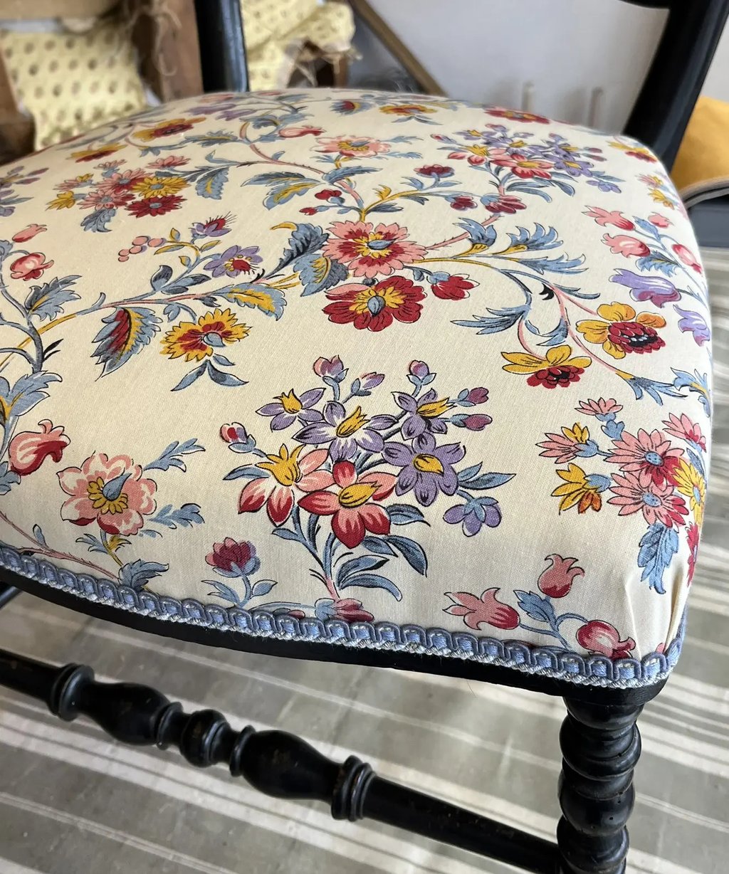 Une chaise Napoléon III avec une assise à motif floral coloré sur fond écru