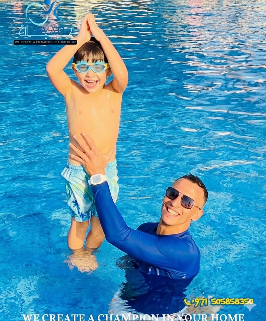 A smiling boy with goggles and a man in a blue rash guard during a fun kids swimming lesson in a pool.