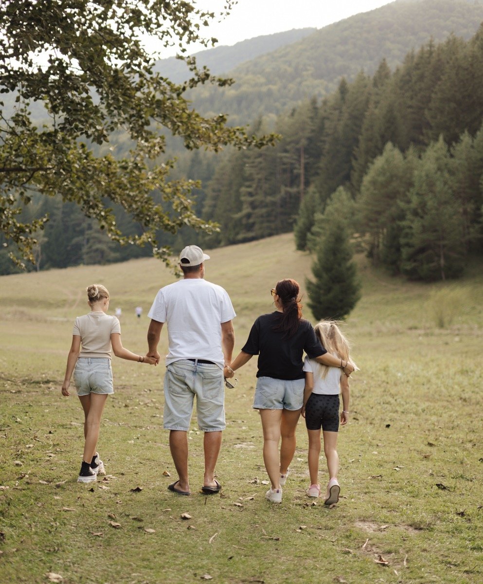 Family of four walking away to the woods