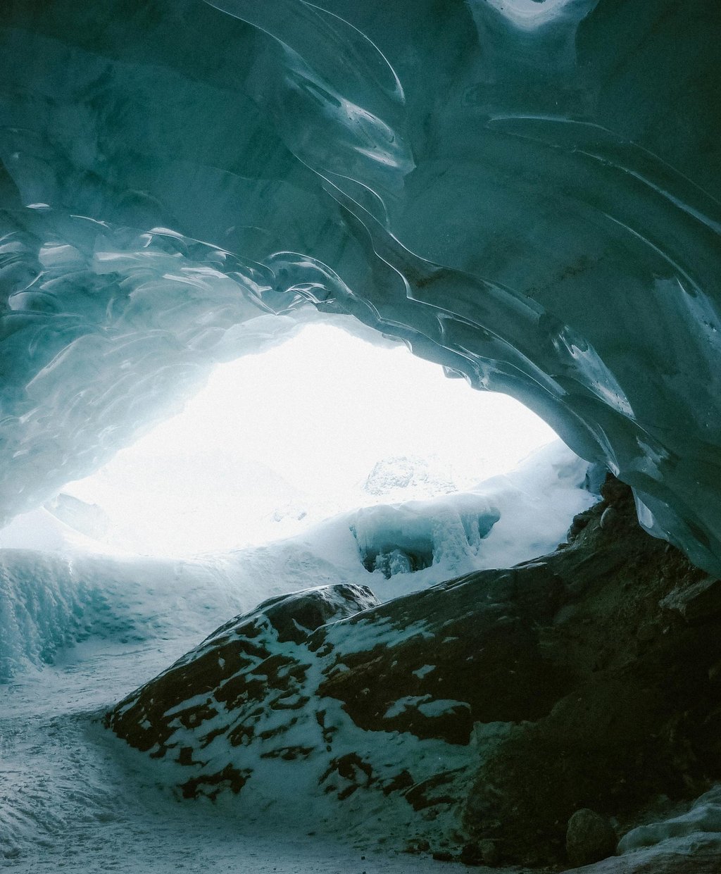 Frozen cave with snow and ice, representing shelter and navigation in extreme cold survival