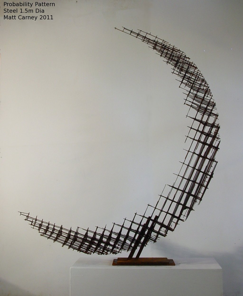 a rusted steel cross-hatched crescent shaped sculpture