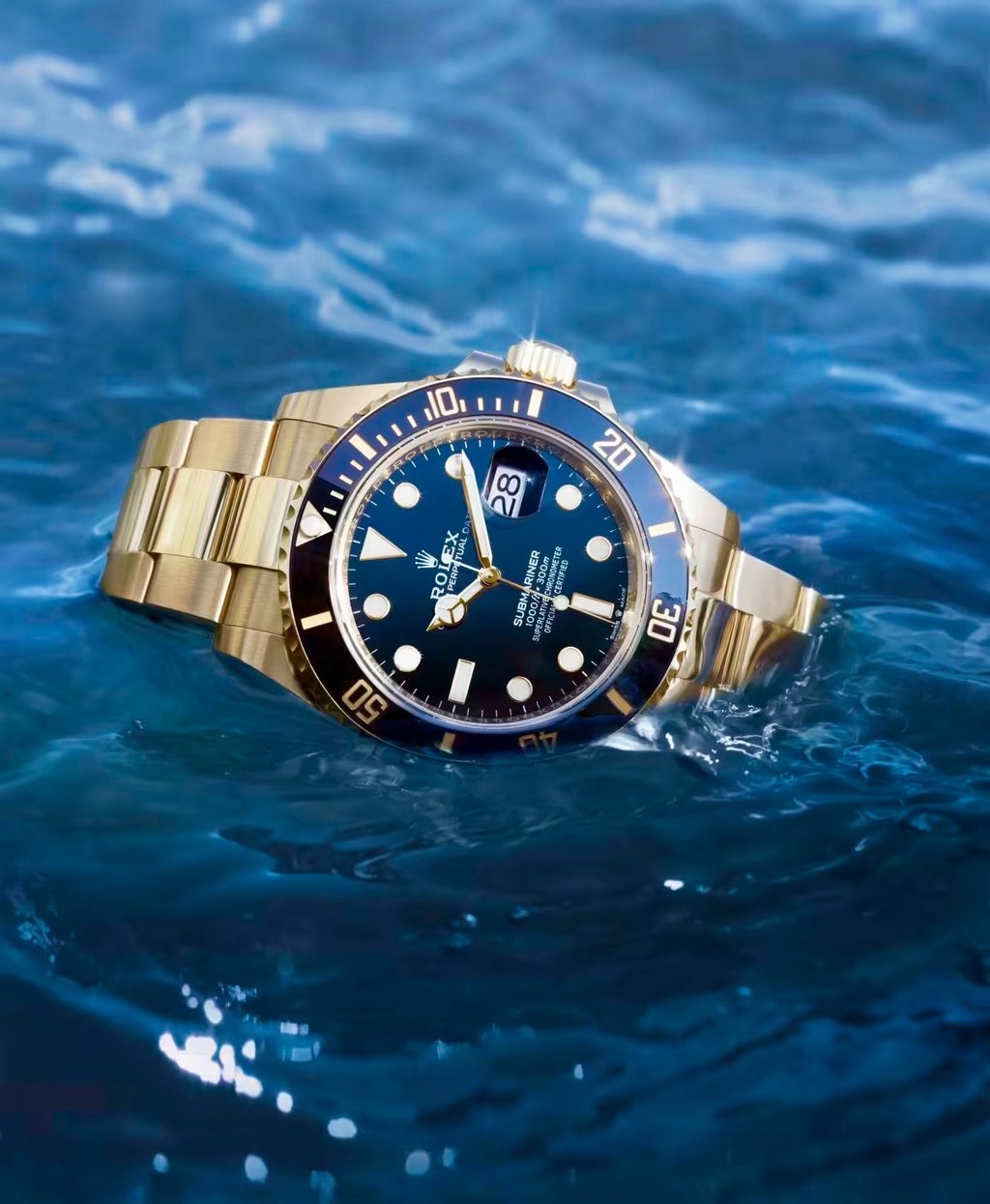 Gold Rolex Submariner luxury dive watch floating on water, showcasing its waterproof design.