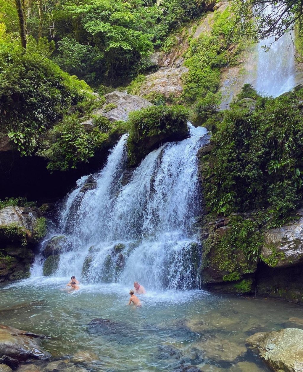 People swimming and enjoying a natural waterfall in Santa Fe, Veraguas, Panama.