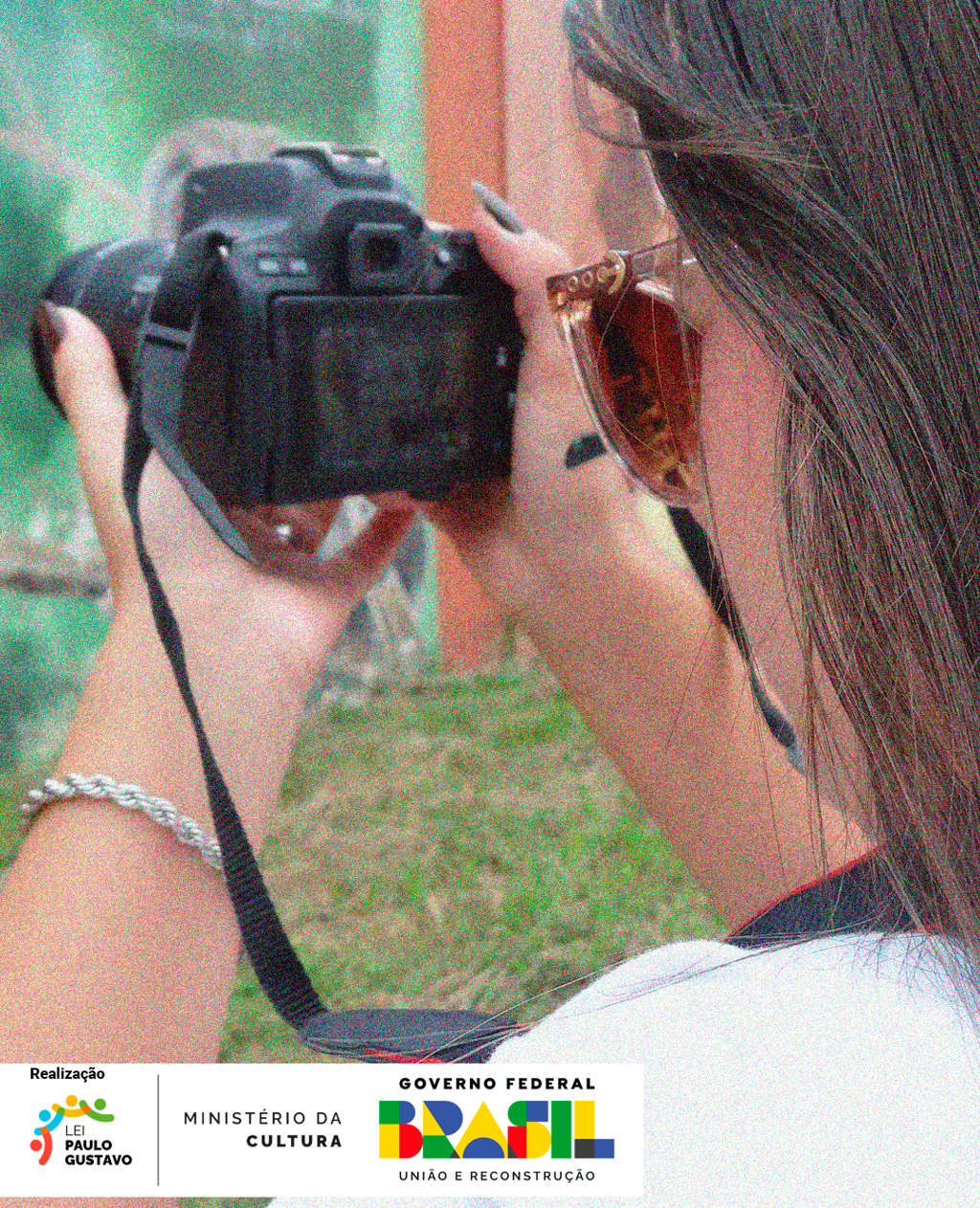 Uma mulher segurando uma câmera fotográfica