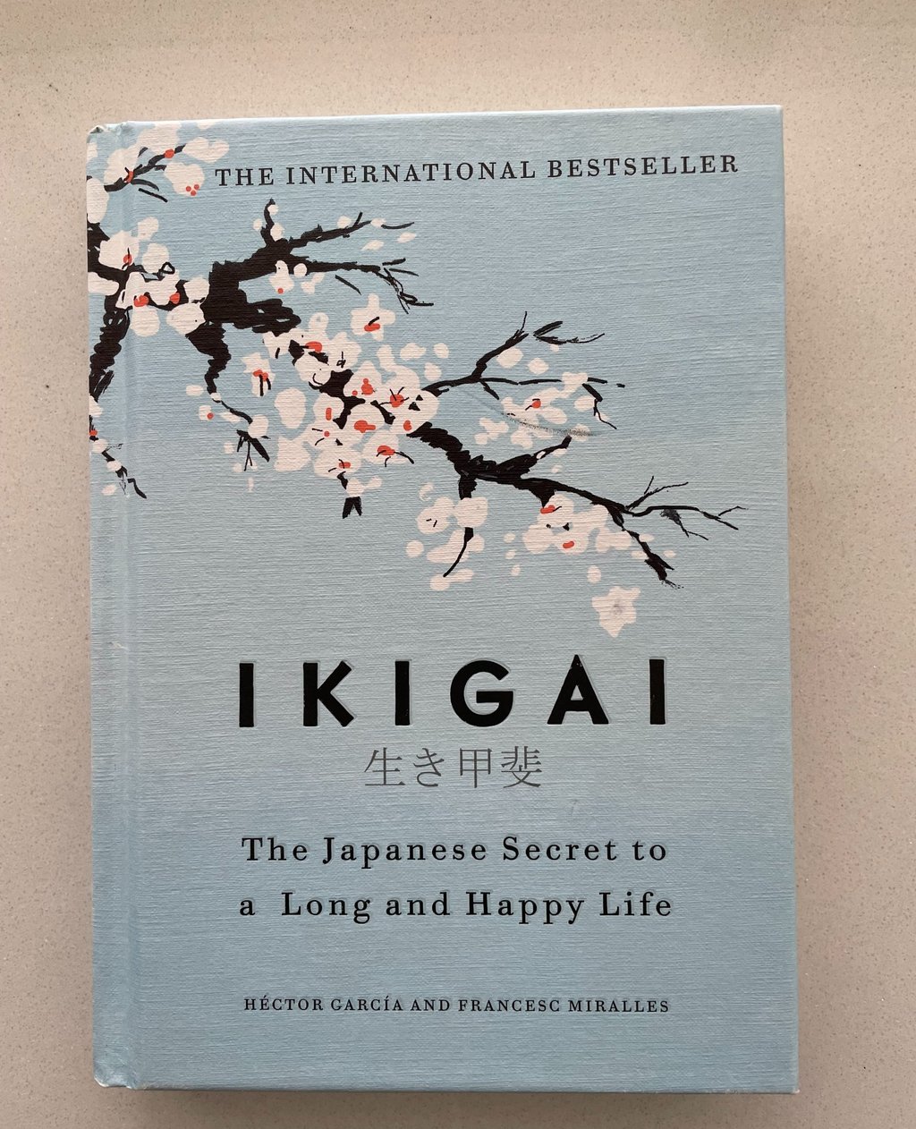 a book cover of a book IKIGAI with a cherry blossom