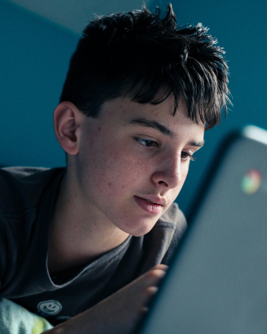 Teenage boy using laptop unsupervised, illustrating risks of online activity