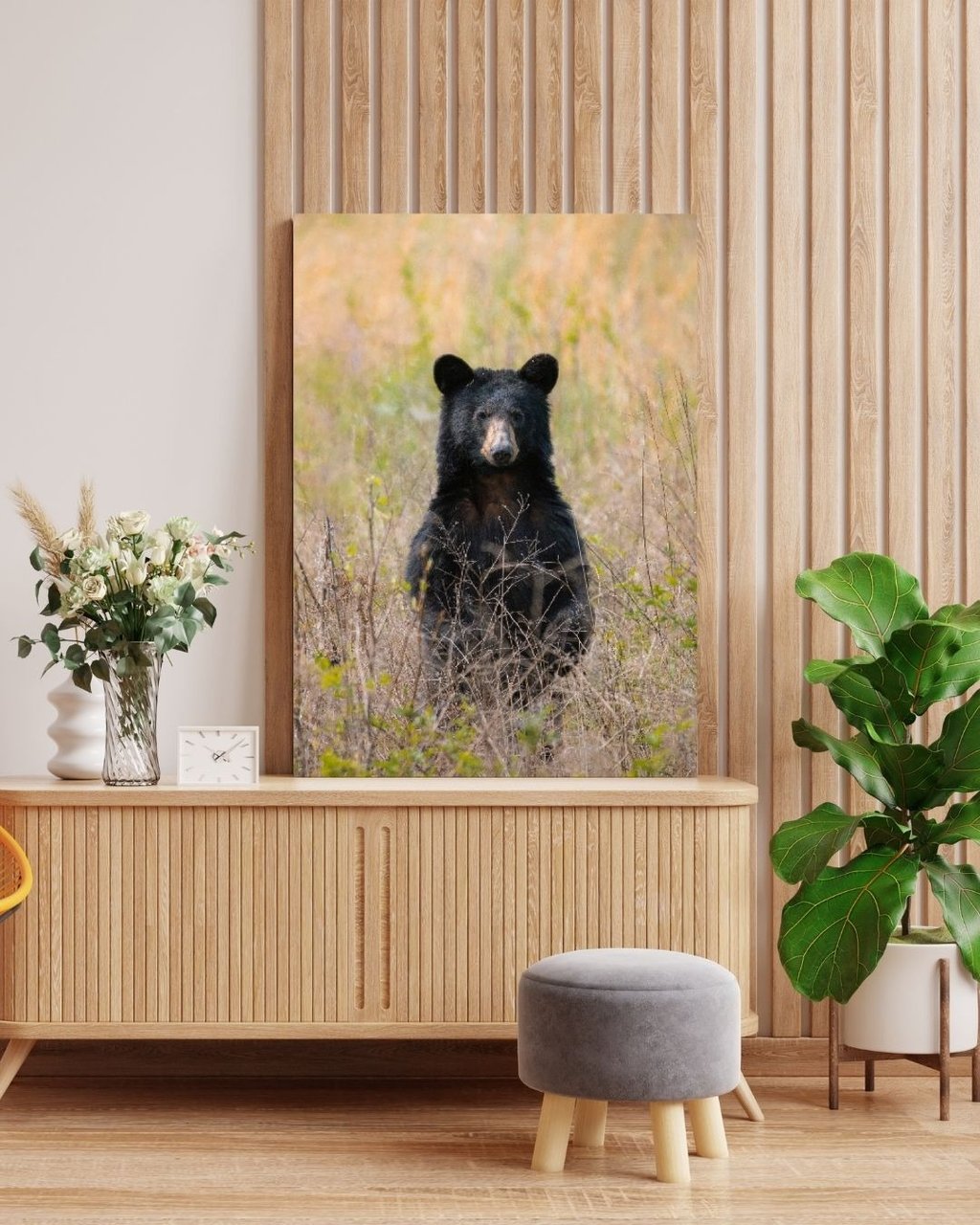 Wild black bear canvas print displayed above a wooden sideboard in a modern living room.