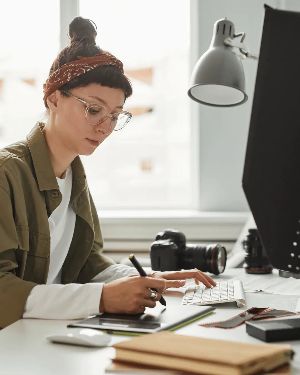 Real estate photo editor working on listing images at a desk with camera gear