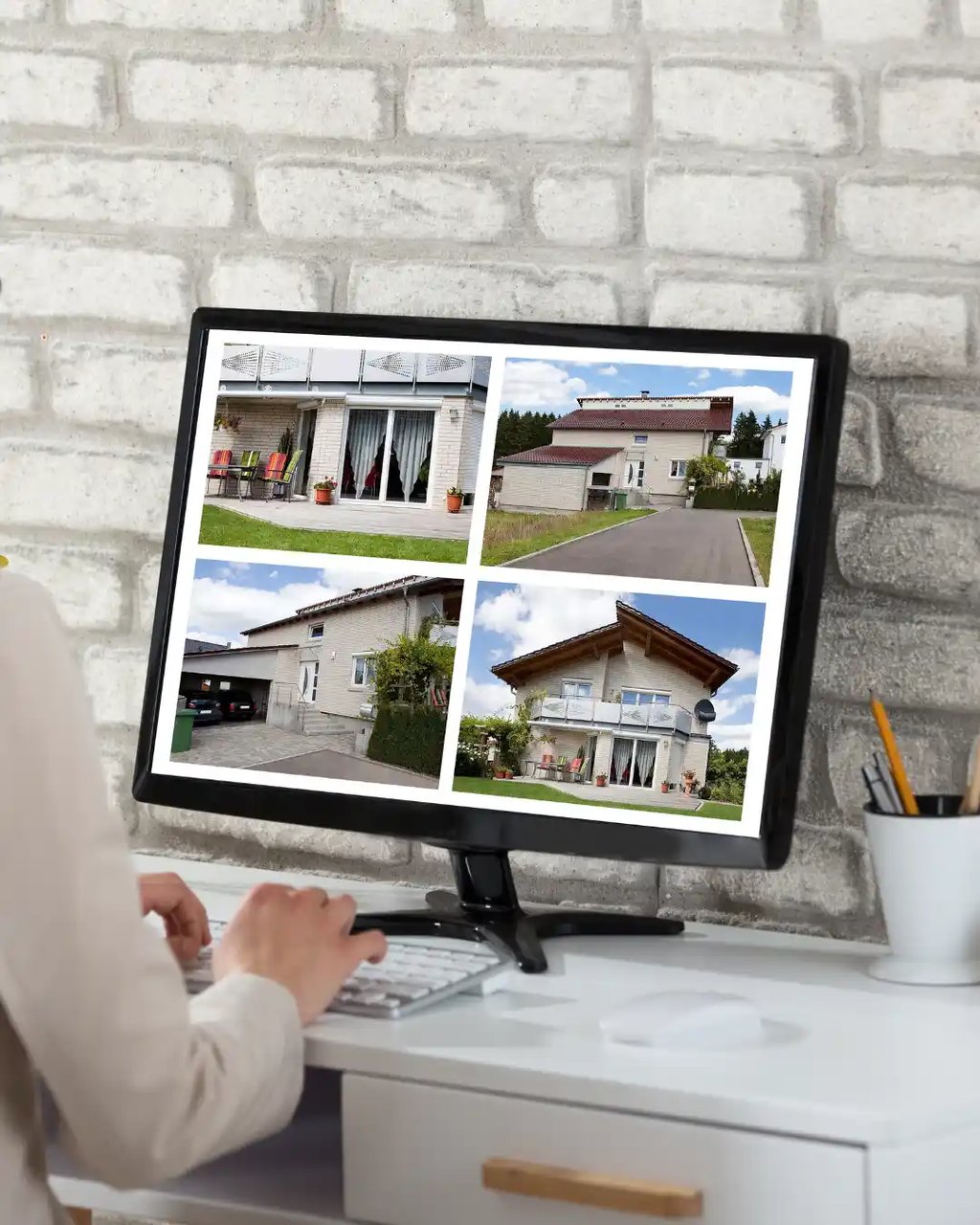 A real estate professional editing property images on a computer to enhance listing photos