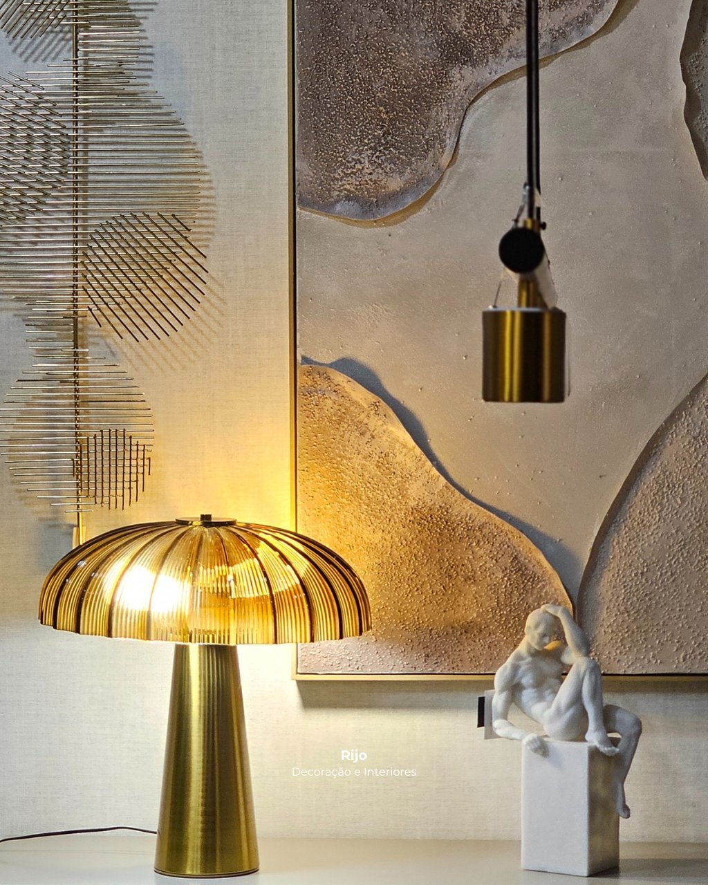 Modern luxury interior featuring a gold ribbed table lamp, white sculpture, and textured wall art.