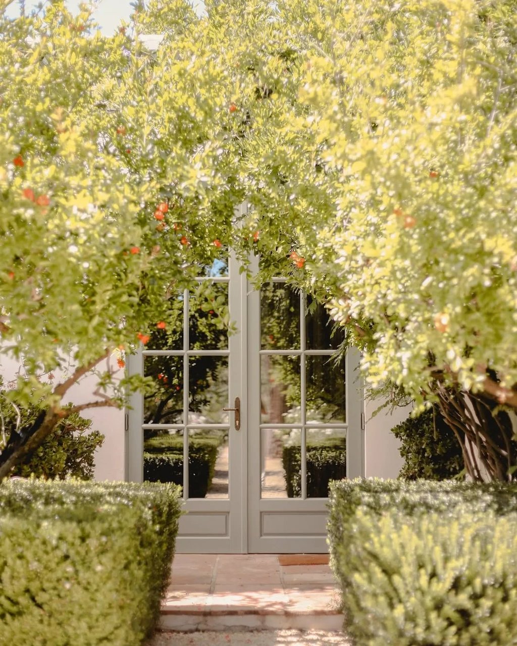 Garden entrance with glass doors framed by flowering trees