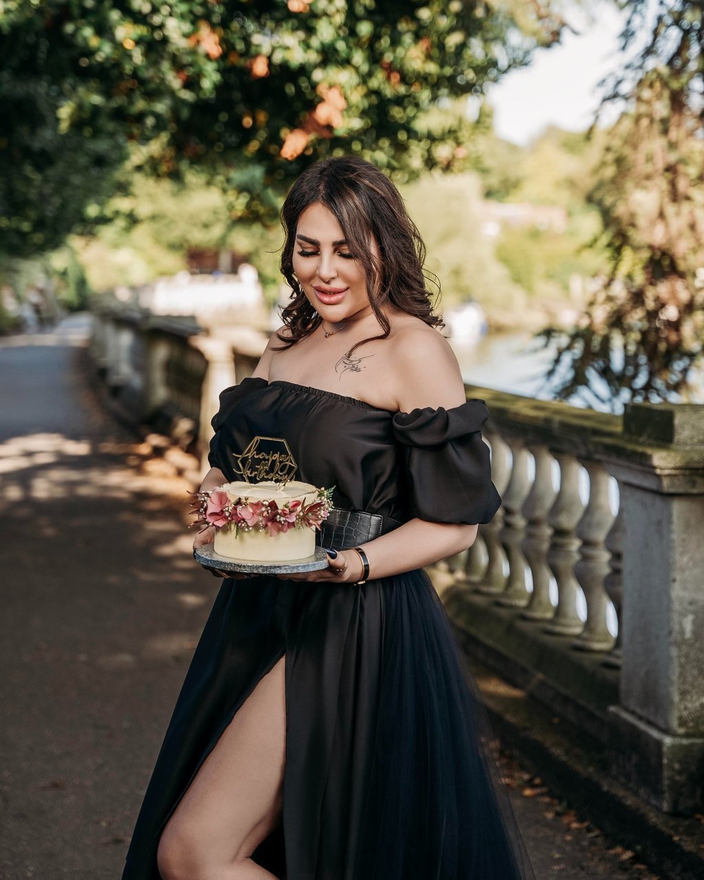 Outdoor portrait of woman in black dress holding cake – Fred Art Studio London
