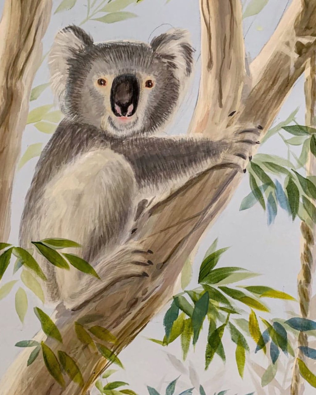 Hand-painted koala resting in a gum tree — Australian nursery mural detail in calm neutral tones.