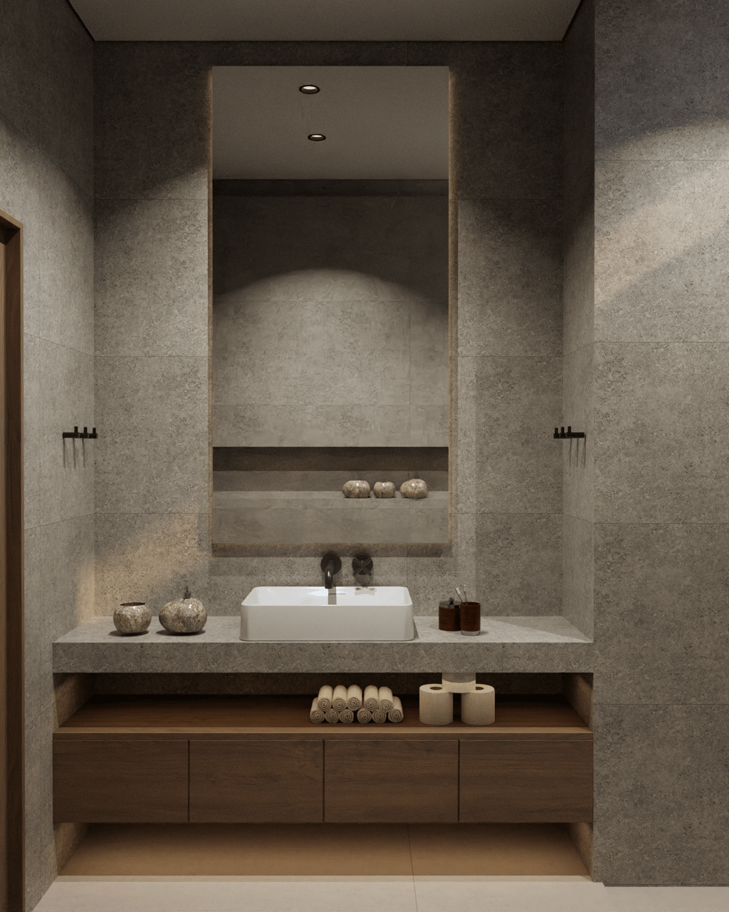 Modern bathroom featuring stone tiles and a large illuminated mirror.