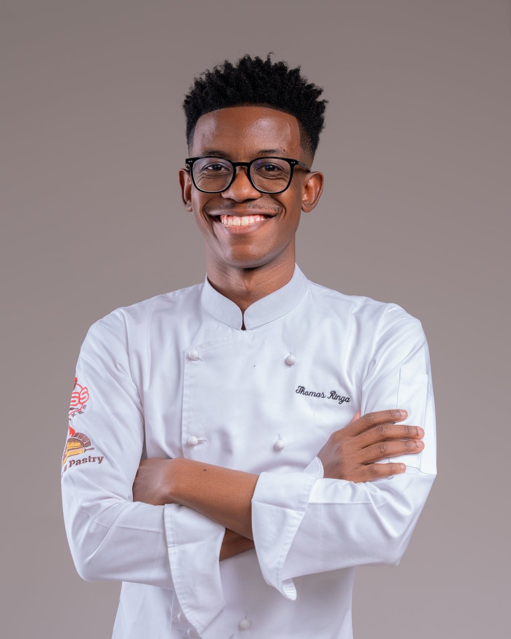 a man in a chef's uniform and glasses