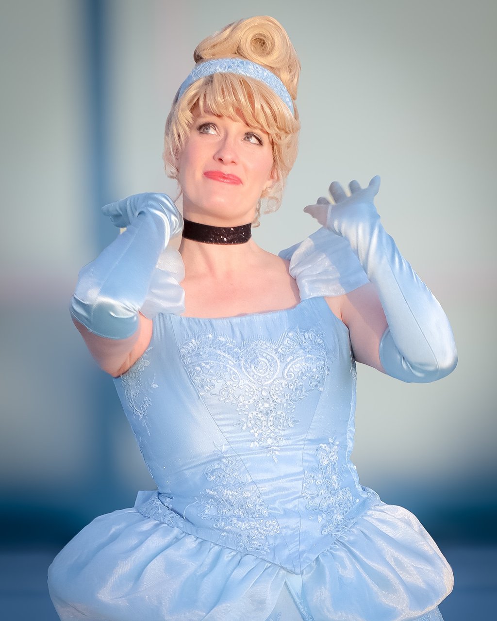 A woman dressed in an ariel cosplay costume featuring a light blue ballgown and matching gloves.