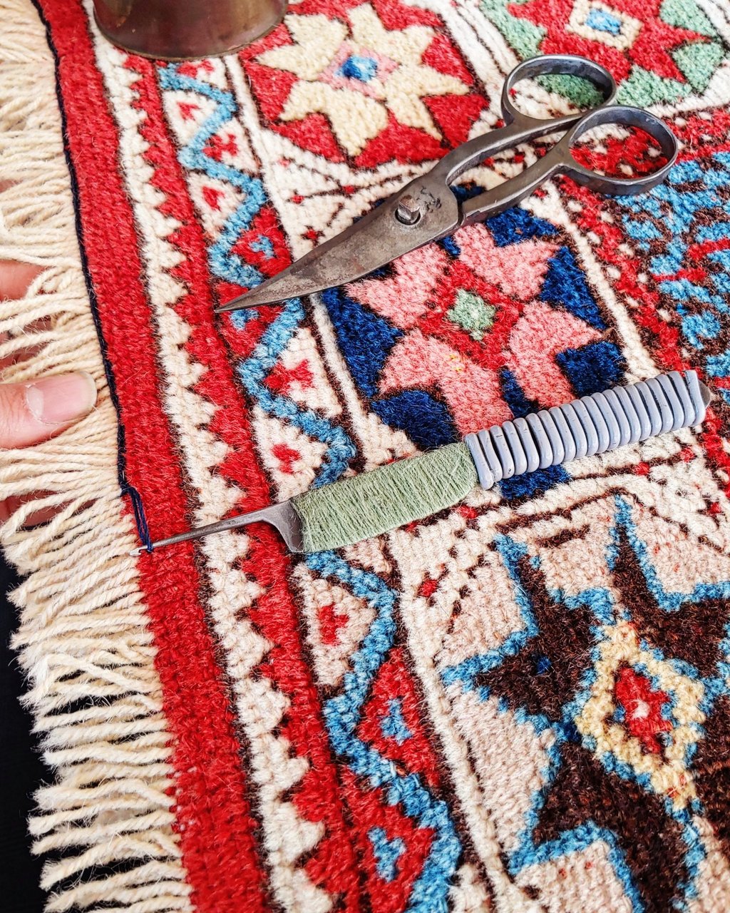 restauratore di tappeti che esegue il bloccaggio delle frange a uncinetto