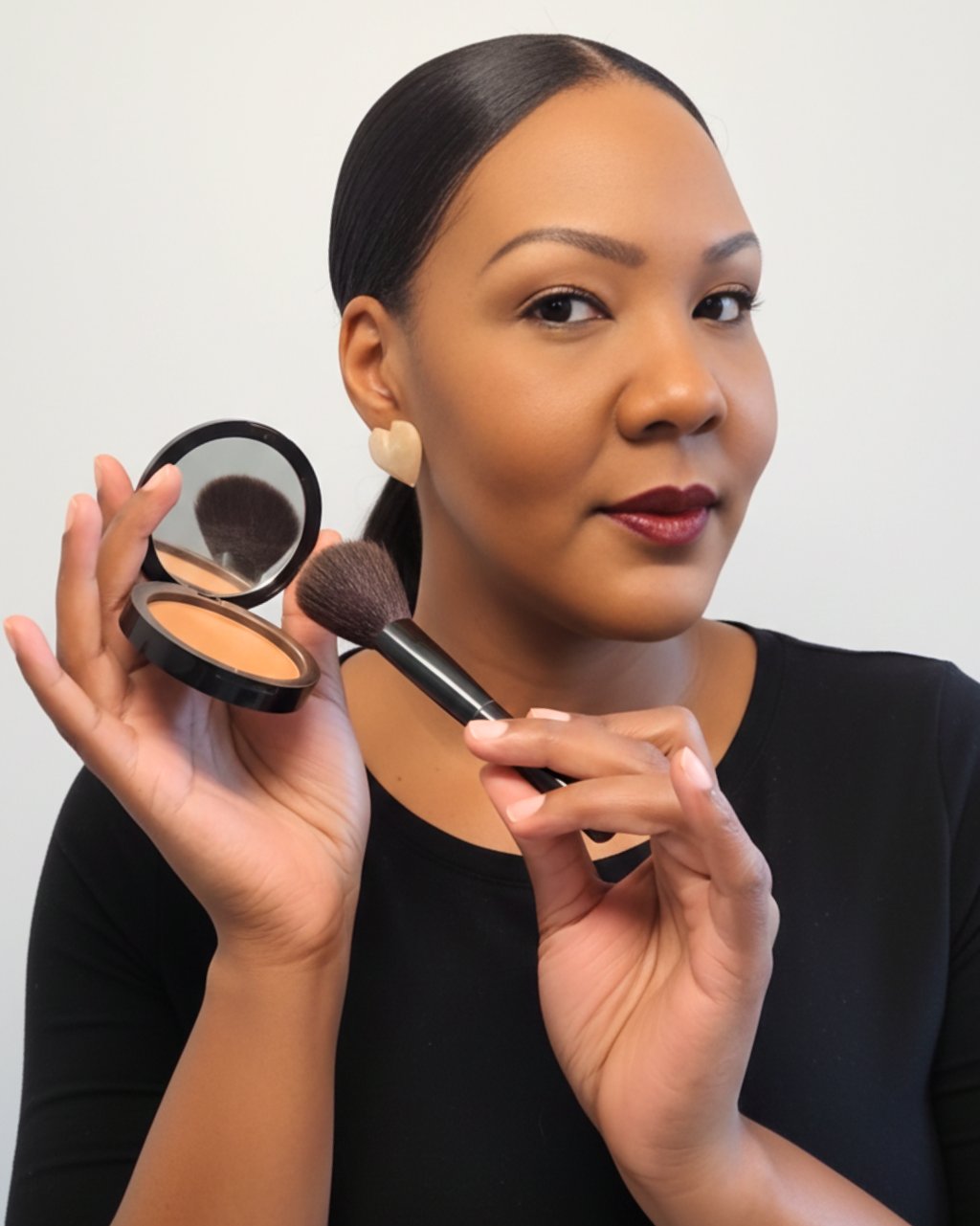 A woman applying face powder with a makeup brush and compact mirror for a flawless finish.