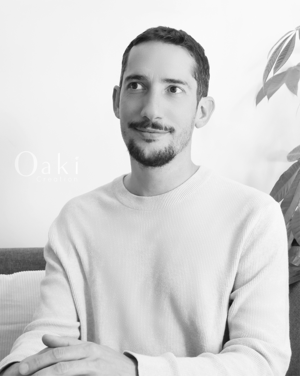 Black and white portrait of a man with a beard and mustache wearing a knit sweater by Oaki Creation.