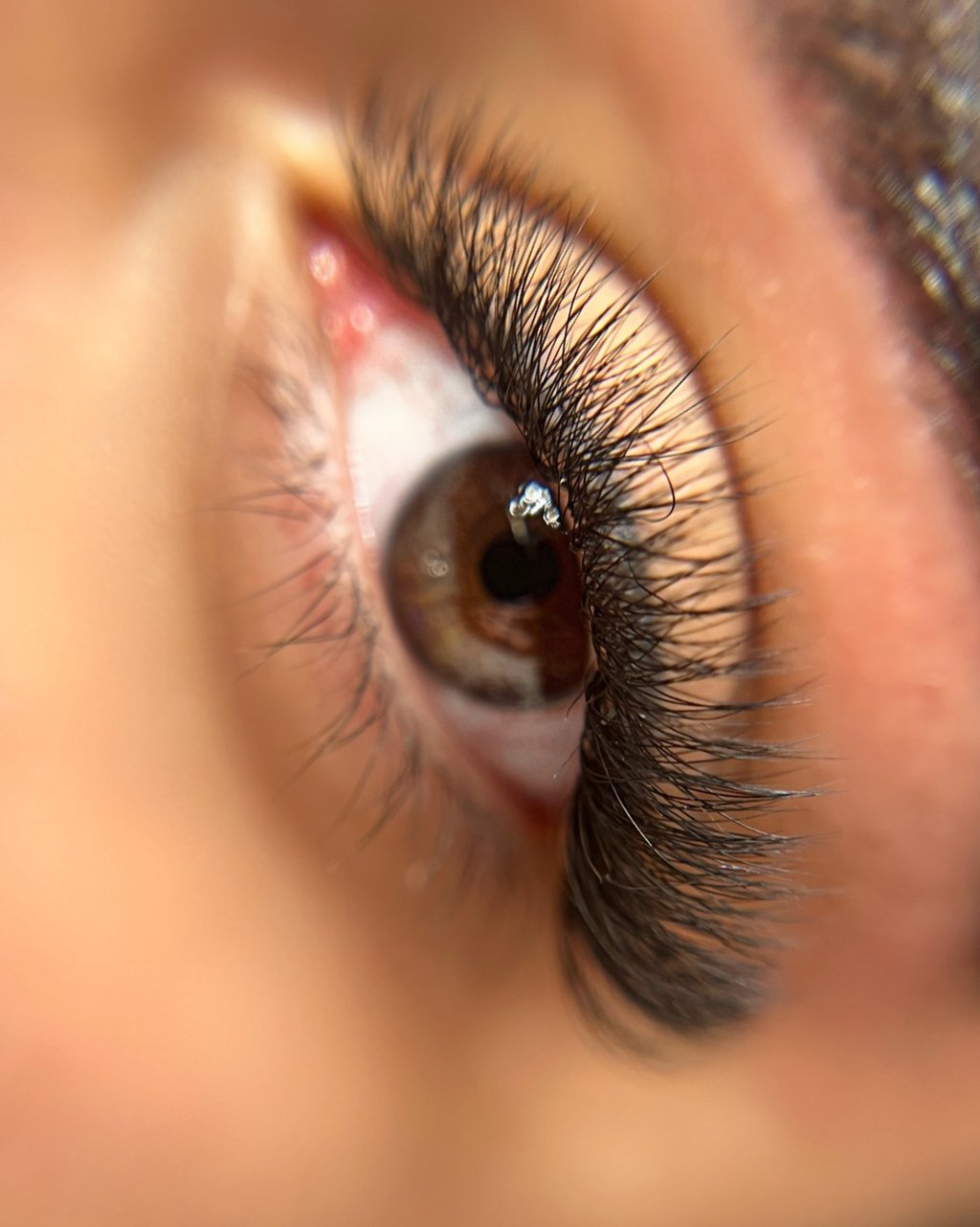 a close up of a woman's eye with eyelash extensions. Made by destheticsalon