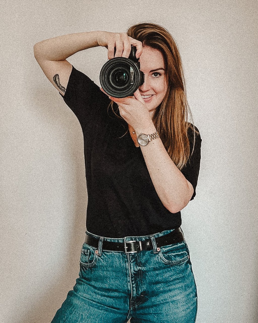 a woman taking a selfie with a camera and holding a camera