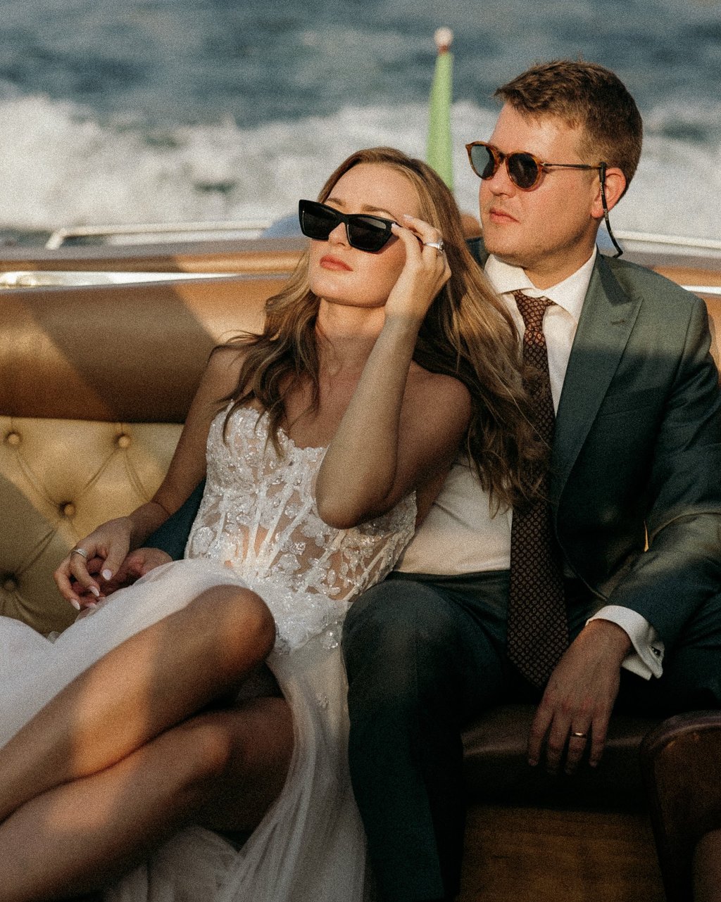 a man and woman sitting on a boat on Lake Como