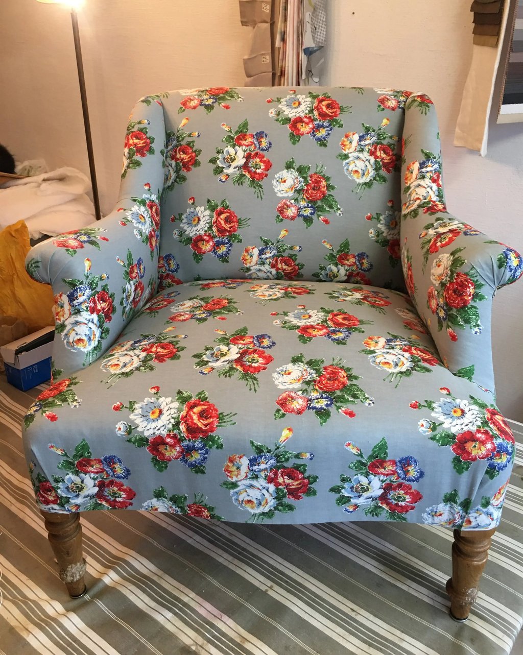 Fauteuil confortable de style anglais recouvert de tissu bleu à motif floral blanc et rouge