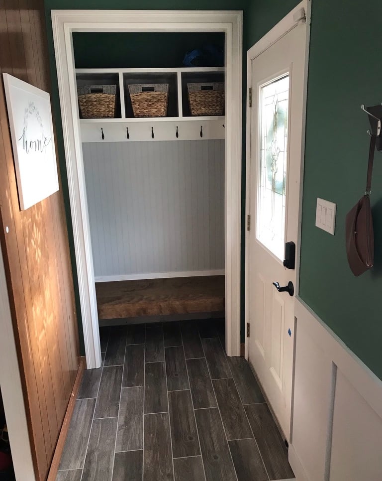 Mudroom with custom shelving floating stained bench and wood look tile by Golden Rule Construction