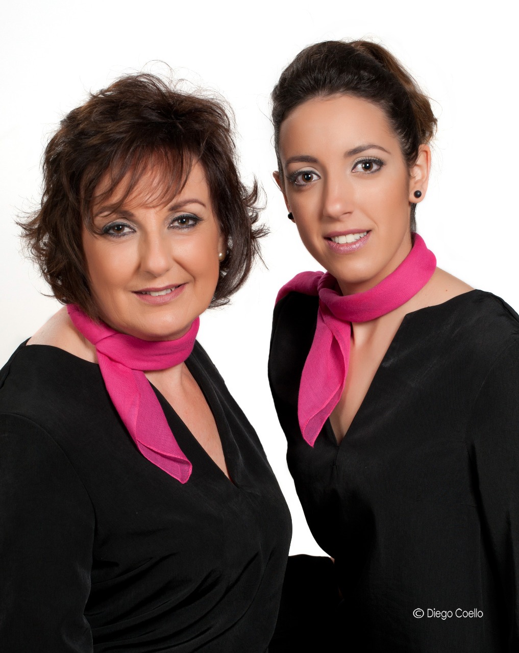 two women in black dresses and pink scarf
