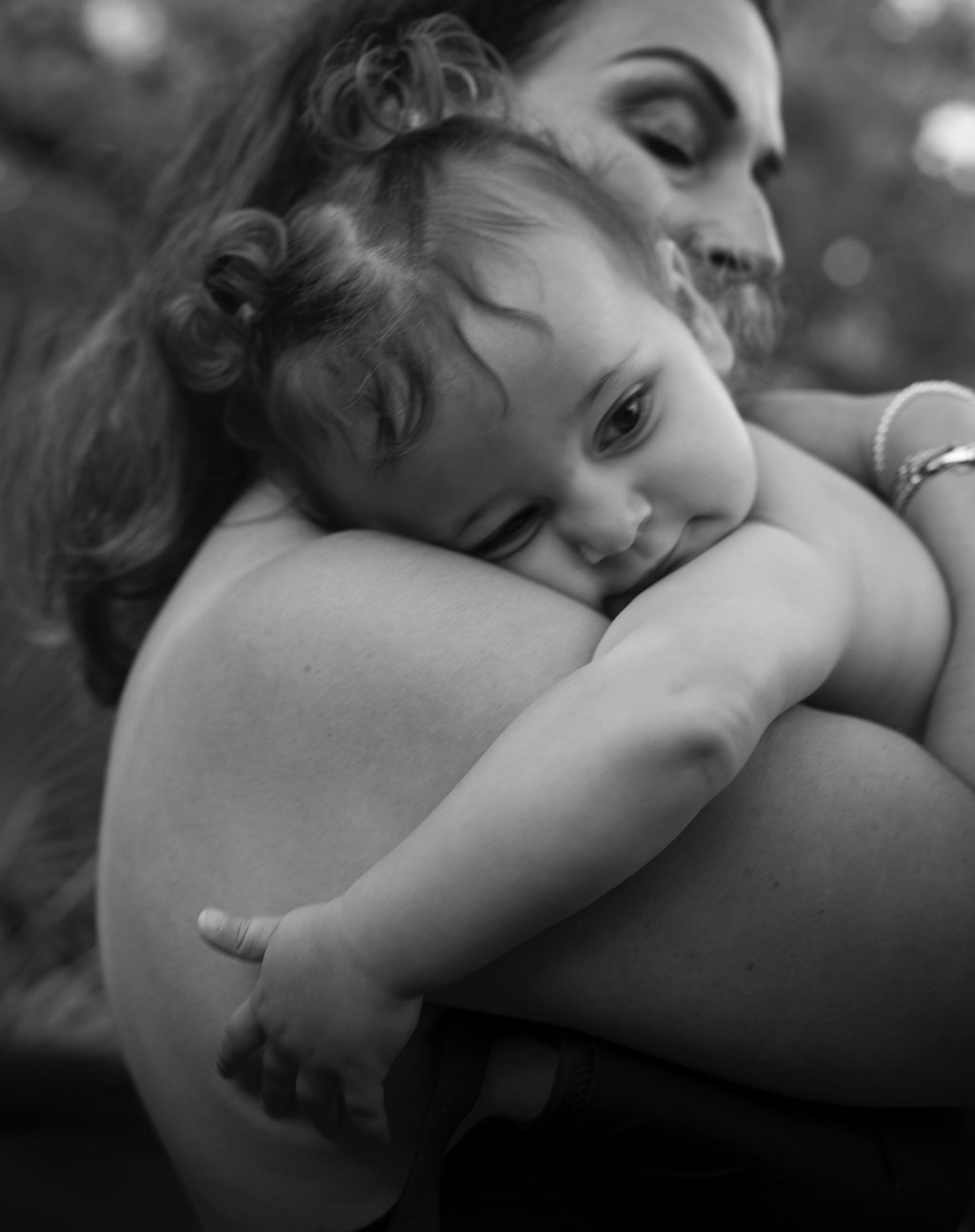black and white image of mother holding her baby on the arms in the intimate moment